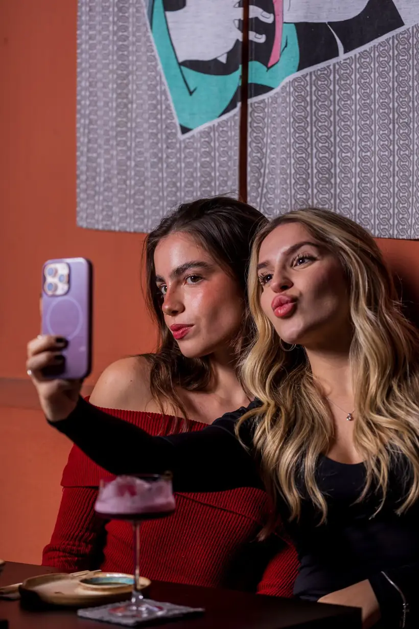 Amigas fazendo selfie com drinks